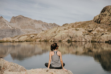 Femme assise au bord d'un lac après une randonnée