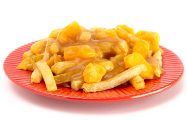Plate of Poutine with Orange Cheddar Cheese with Brown Gravy on French Fries