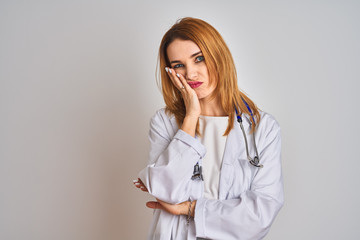 Redhead caucasian doctor woman wearing stethoscope over isolated background thinking looking tired and bored with depression problems with crossed arms.