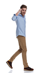 Side view of handsome casual man saluting
