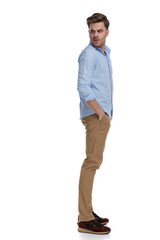 Fototapeta premium Side view of upset casual man looking over shoulder