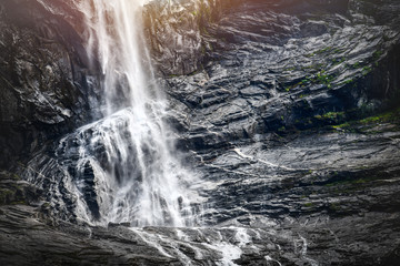 Obraz na płótnie Canvas Panoramic beautiful deep forest waterfall in norway near blue ocean. Waterfalls mountain view close up.