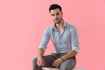 Attractive smart casual man holding his glasses while shirt