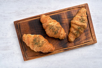 Croissants with zaatar  on  wooden board . Top view     