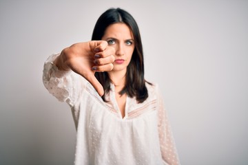 Young brunette woman with blue eyes wearing casual t-shirt over isolated white background looking...
