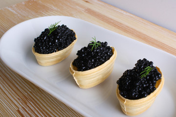 black caviar tartlet wooden background