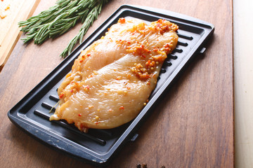chicken breast in marinade spice, board, rosemary