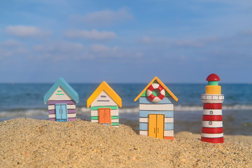Miniature huts and lighthouse at beach