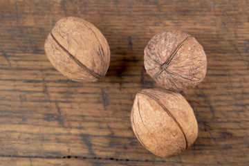 group of fresh raw walnuts on grunge wooden background. rustic and detailed image. looking from above.