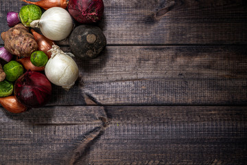 Set of vegetables on a wooden background. Eating vegetables and healthy nutrition. Eating onions, brussels sprouts, shallots, turnips and other vegetables.