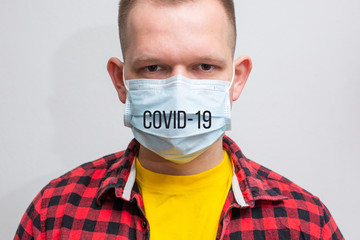 A man in a medical mask with the inscription COVID - 19