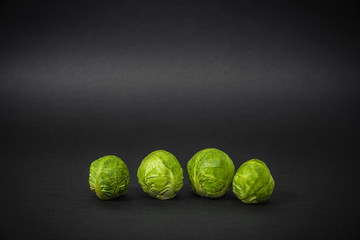Brussels sprouts on a dark black background. The concept of food and cooking. Eating vegetables and...