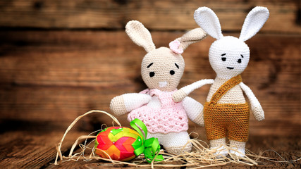 Colorful easter egg and easter hand made rabbits on wooden background.