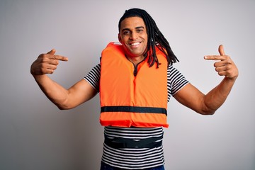 Young african american afro man with dreadlocks wearing orange lifejacket looking confident with...
