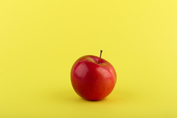 red apple on yellow background with copy space