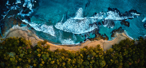 Herrliche Luftaufnahme einer blauen tropischen Lagune mit kristallklarem Wasser, umgeben von Strand und Palmen.