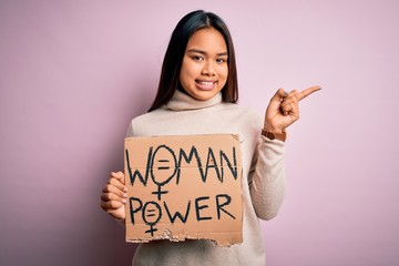 Young asian activist girl asking for women rights holding banner with woman power message very...