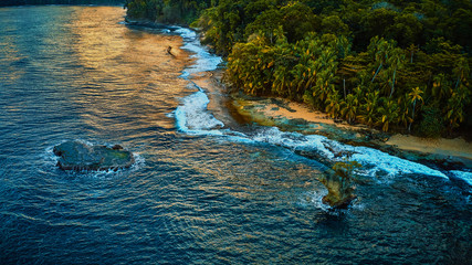 Beautiful shot of a wild nature of exotic island with green palms and sand surrounded by transparent turquoise ocean water
