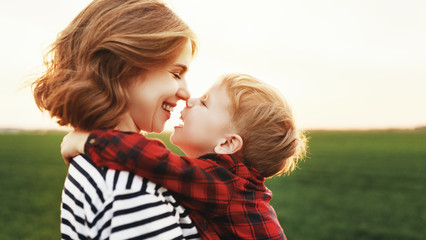 Mother and son hugging in field.