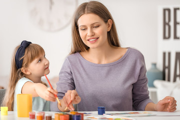 Fototapeta premium Drawing teacher giving private art lessons to little girl at home