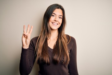 Young beautiful girl wearing casual sweater standing over isolated white background showing and pointing up with fingers number three while smiling confident and happy.