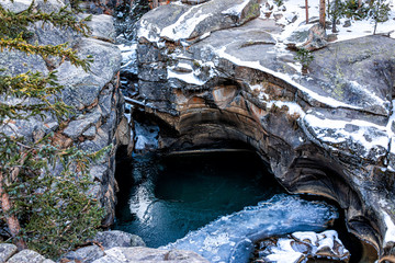 Independence Pass snow area rocky mountain closeup view of grottos cave pool near scenic byway in...