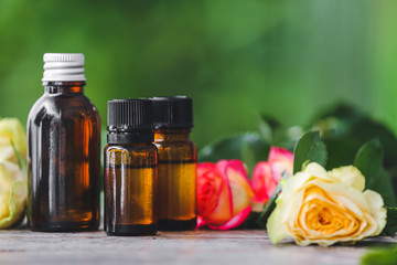 Bottles of rose essential oil on table