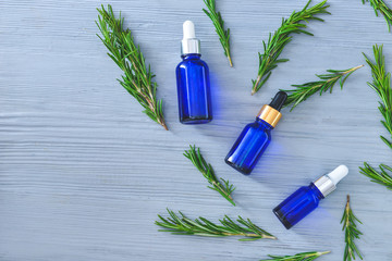 Bottles of rosemary essential oil on table