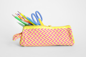 Pencil case with stationery on white background