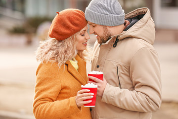 Happy young couple drinking hot cocoa outdoors