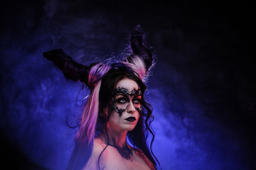 Portrait photo of a mystic young girl in a magic creature cosplay, wearing dark banshee make-up and...