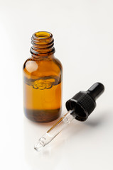 Natural organic oil isolated on white background. Body oil in brown bottle.