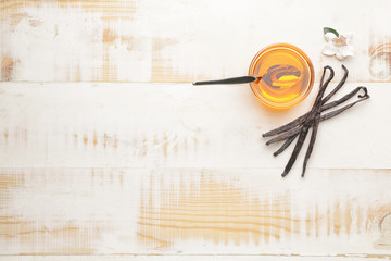 Aromatic vanilla extract on wooden background