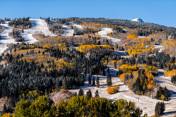 Aspen, Colorado buttermilk or highlands ski slope hill in rocky mountains view on sunny day and peak with snow on yellow foliage autumn trees