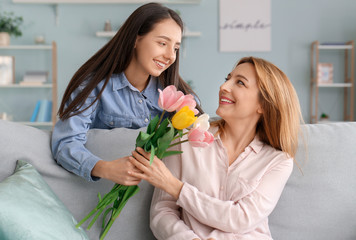 Adult daughter greeting her mother at home