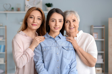 Mature woman with her adult daughter and mother spending time together at home