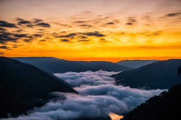 Mountains landscape clouds foggy mist in morning above new river gorge valley in Grandview Overlook, West Virginia during morning colorful sunrise