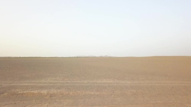 Panoramic top view of the Maranjob desert. A drone flies over the sands and dunes. Visible salt on sand and blue clear sky