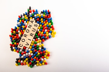 Map of Germany with text corona virus in the middle, in several colors representing all nationalities that life in Germany, build with wooden figurines, white background