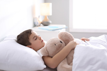Little boy sleeping with teddy bear at home. Bedtime