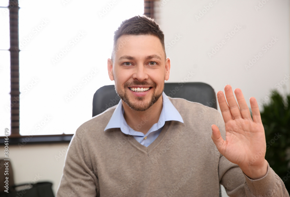 Poster man using video chat in office, view from web camera