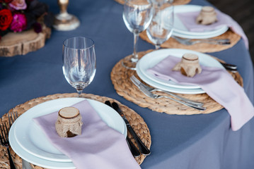 Festive table setting. White round plates decorated of small jar of honey, cutlery, glasses on the table
