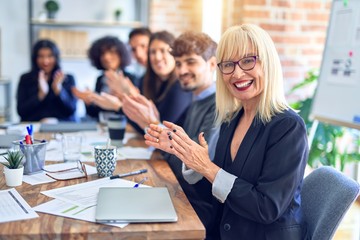 Group of business workers smiling happy and confident. Working together with smile on face looking at the camera applauding at the office