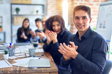 Group of business workers smiling happy and confident. Working together with smile on face looking at the camera applauding at the office
