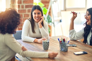 Group of businesswomen smiling happy and confident. Sitting relaxed with smile on face. Speaking taking rest at the office