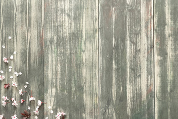 aged wooden background with flowers and pink petals