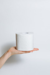 A roll of toilet paper in hand in case of an epidemic. COVID-19 coronavirus outbreak concept. Shortage due to buying panic. White background