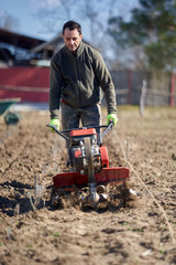 Farmer weeding the field with a tiller