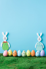 Wooden toy rabbits with colored Easter eggs.