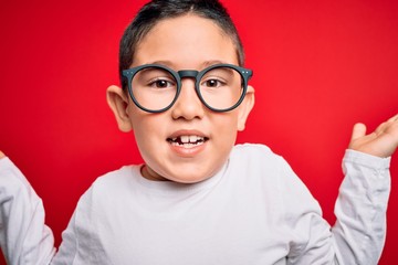 Young little smart boy kid wearing nerd glasses over red isolated background very happy and...